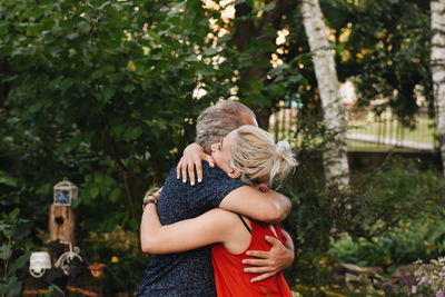 Rear view of women and man hugging each other 