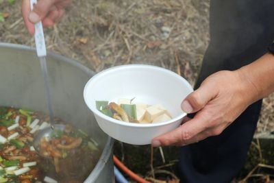 High angle view of woman holding ice cream in bowl