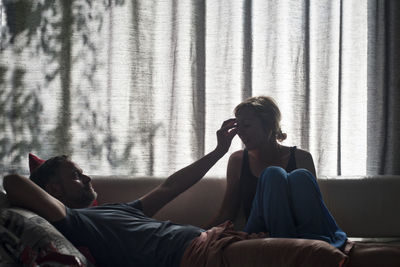 Friends relaxing on bed at home