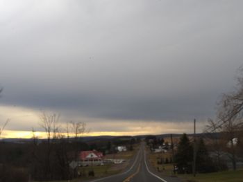 Cars on road against sky during sunset