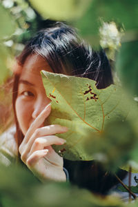 Close-up portrait of woman with leaves