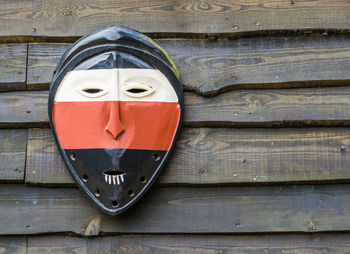 Close-up of mask hanging on wooden wall