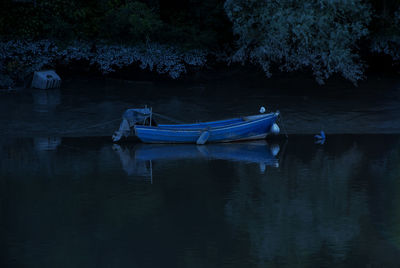 Boats moored in lake at night