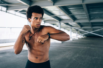 Young man exercising under bridge 