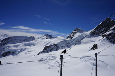 Snow covered mountains against blue sky