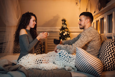 Young couple sitting on sofa at home