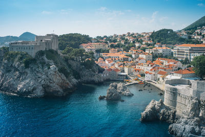 Aerial view of buildings and sea against sky