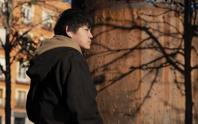 Asian teenage boy with earphones on street. madrid. spain