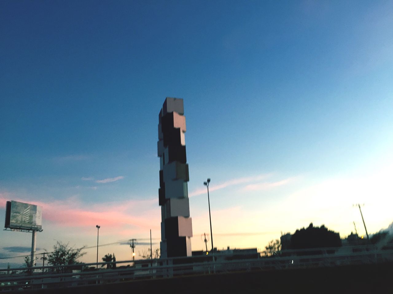 architecture, built structure, building exterior, sky, sunset, low angle view, blue, tower, tall - high, city, copy space, silhouette, outdoors, cloud - sky, transportation, travel, sea, no people, travel destinations, cloud