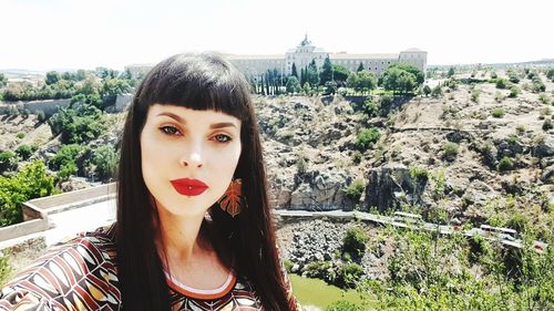 Portrait of beautiful young woman against built structure