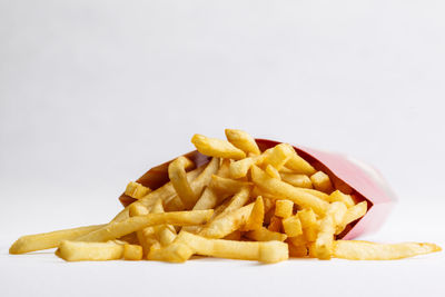 Close-up of fries with yellow noodles on white background