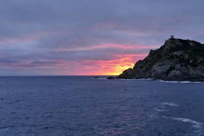 Scenic view of seascape against cloudy sky during sunset