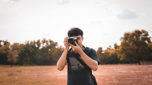 Man photographing against sky