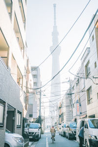 Cars on street amidst buildings in city against sky