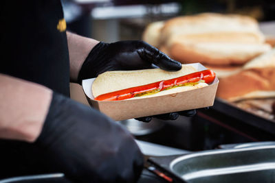 Close-up of man preparing food on barbecue grill