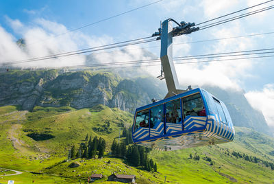 Overhead cable car over mountains against sky