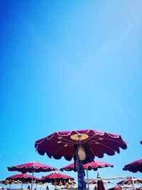 Low angle view of carousel against clear blue sky