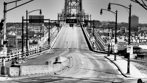 Bridge over street in city against sky