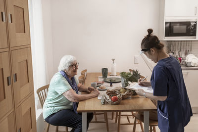 Home carer helping senior woman at home