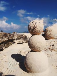 Stack of stones on beach against sky