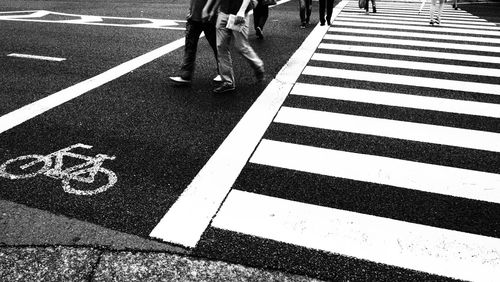 Low section of people walking on zebra crossing