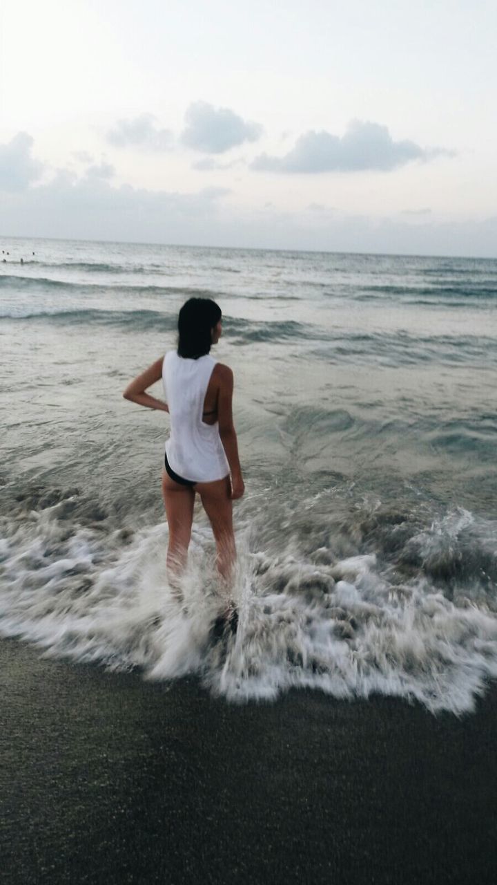 sea, beach, water, horizon over water, full length, shore, leisure activity, sky, lifestyles, rear view, childhood, sand, wave, casual clothing, tranquil scene, elementary age, vacations, scenics