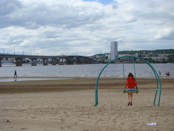 Woman standing on beach against sky