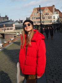 Beautiful woman standing by canal in city