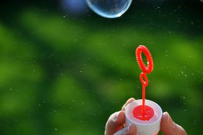 Cropped hand of person holding bubble wand