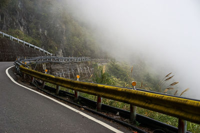 Train on bridge in foggy weather against sky