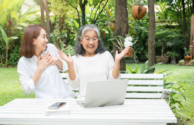 Woman sitting on table while looking at camera