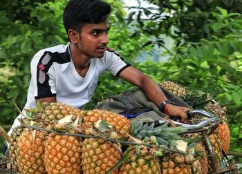 Close up view of farmer transporting pineapple by bicycle to the local market