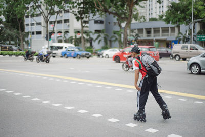 Full length of man roller skating on city street