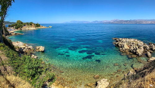 Scenic view of bay against clear blue sky