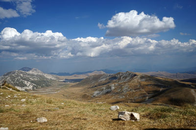 Scenic view of field and mountains against sky