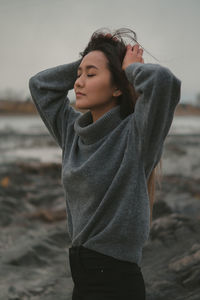Portrait of young woman standing at beach