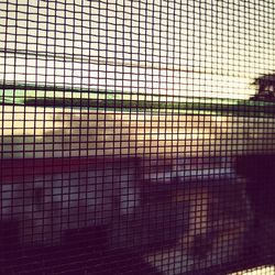 Full frame shot of metal fence against sky during sunset