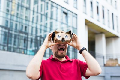 Man wearing virtual reality headset while standing outdoors