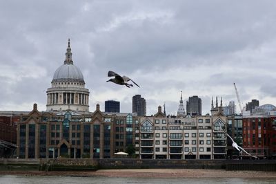 View of buildings in city against cloudy sky