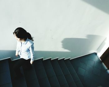 High angle view of young woman on staircase in building