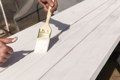 Midsection of person holding umbrella on table