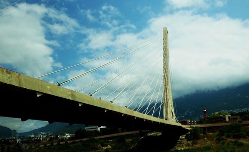 Low angle view of suspension bridge against sky