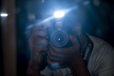 Midsection of man holding camera