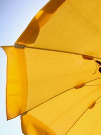 Low angle view of yellow paper against sky