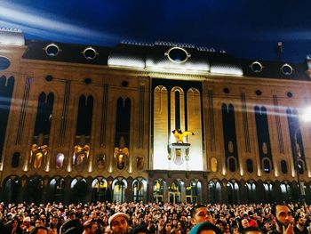 Group of people at illuminated building at night