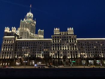 Low angle view of illuminated buildings against sky at night