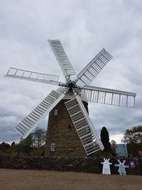 Traditional windmill on field against sky