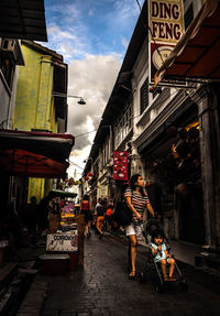 People walking on road along buildings