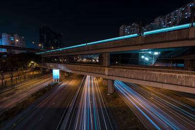 Light trails on bridge in city at night