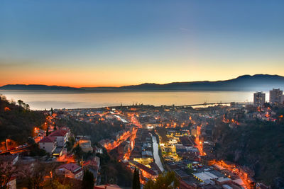 High angle view of illuminated city against sky during sunset